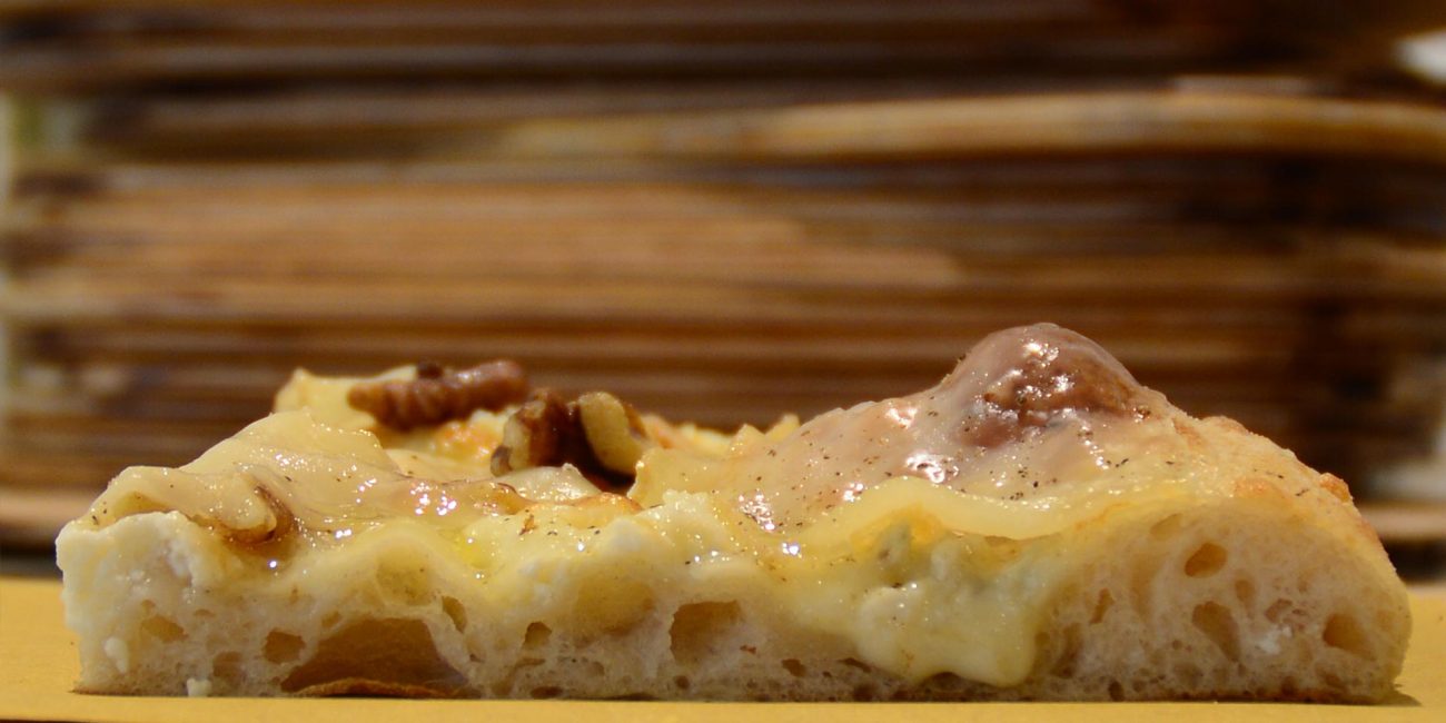 Un trancio di pizza ai quattro formaggi, la preferita di Stefano, il fondatore de Il Pizzicotto